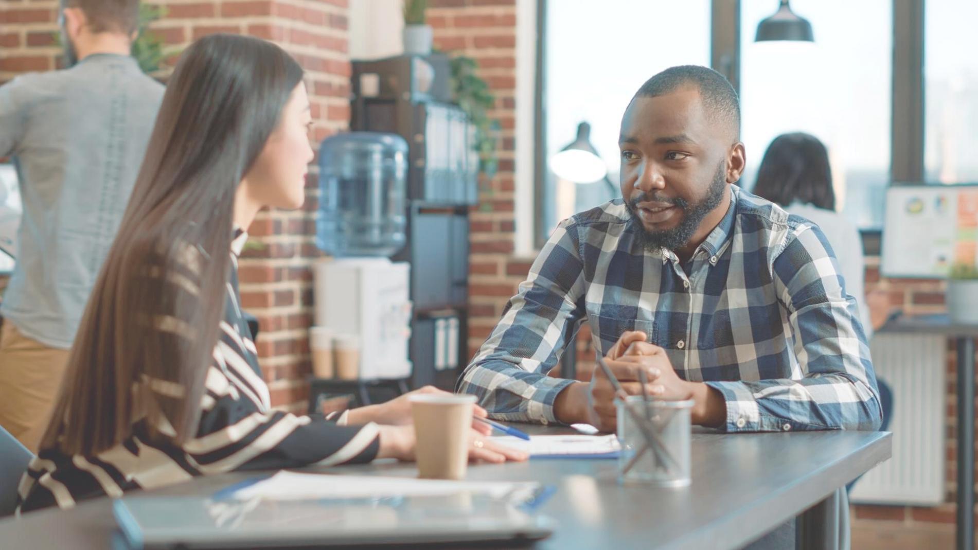 Teammitglieder diskutieren Finanzmodelle vor einem großen Monitor